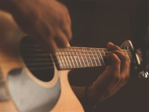 Closeup of acoustic guitar and hands